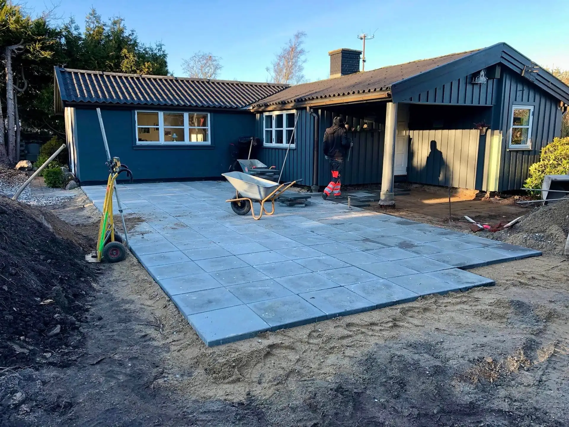 Nylagt flisebelægning ved et blåt hus i Nordsjælland